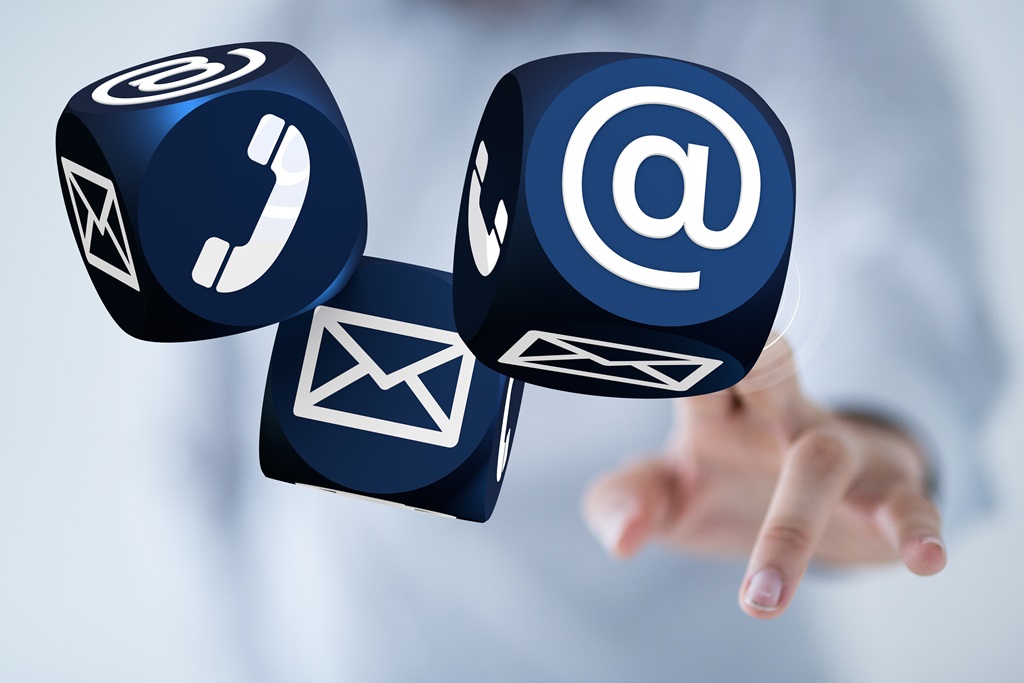 Kontakt zum Institut Drei Würfel, die die Symbole Telefon, E-Mail und @-Zeichen zeigen und eine Hand die die Würfel antippt